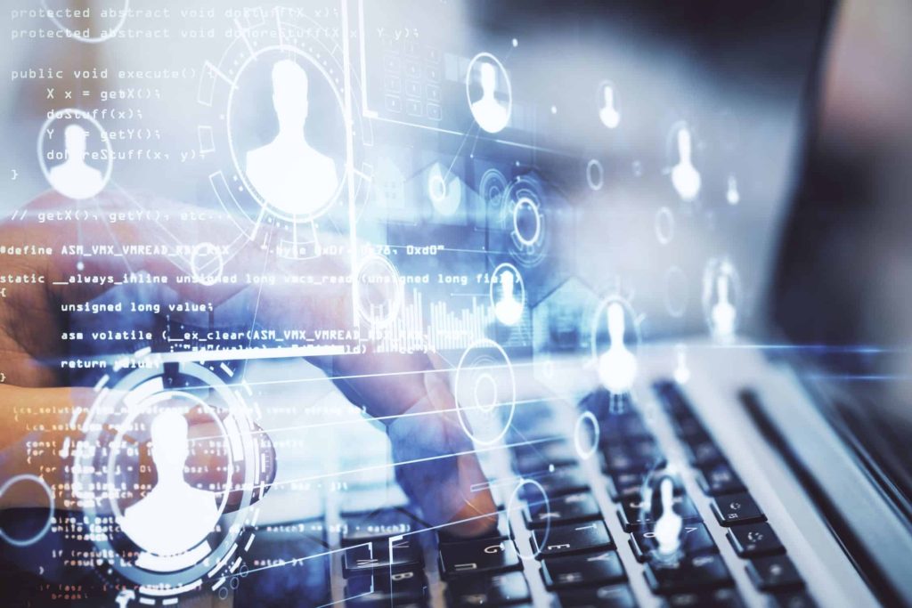 The image is a close up of a laptop with someone's hand typing on it. This is overlayed with people icons floating around to signify HR data being processed.